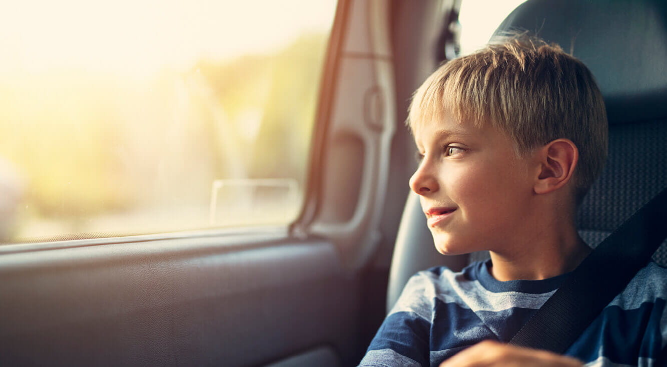 Comprehensive Car insurance - Young boy gazing out of a car window