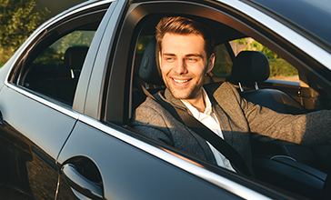 Car insurance - Young man reflected in a car side mirror