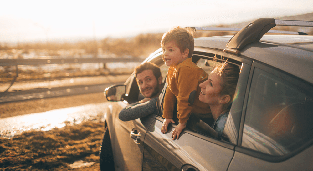 Comprehensive car insurance banner parents and boy leaning out of car window