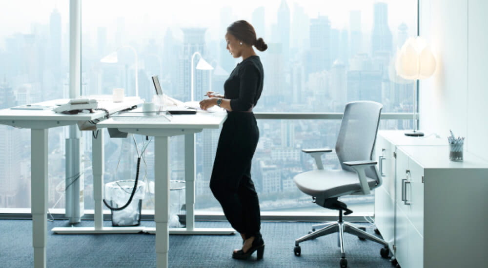 Businesswoman working with her laptop at a standing desk in office building