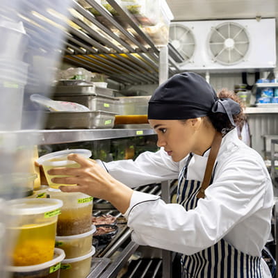 Female hospitality worker stacking take-away containers