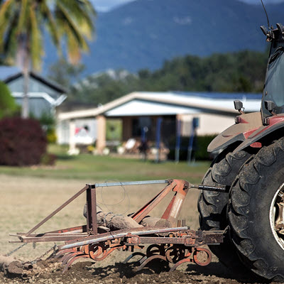 Tractor and plough sitting in outsdie farm buildings