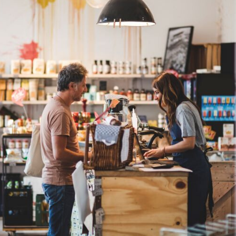 Male customer purchasing goods at a shop counter