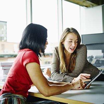 Two businesswomen looking at a tablet together