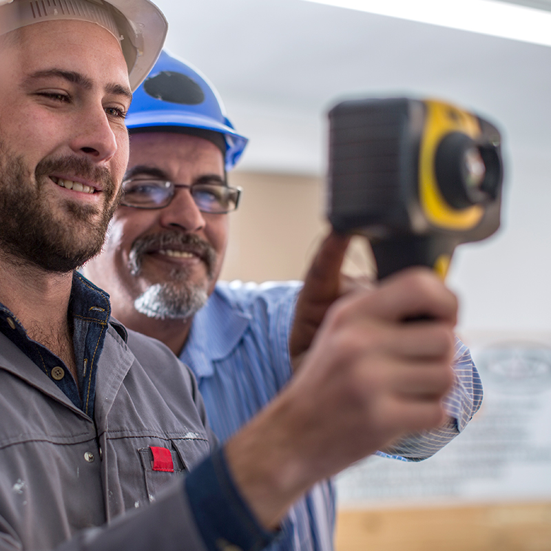 Two men looking at an image on a thermal imaging camera