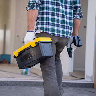 Male tradesperson carrying their toolbox