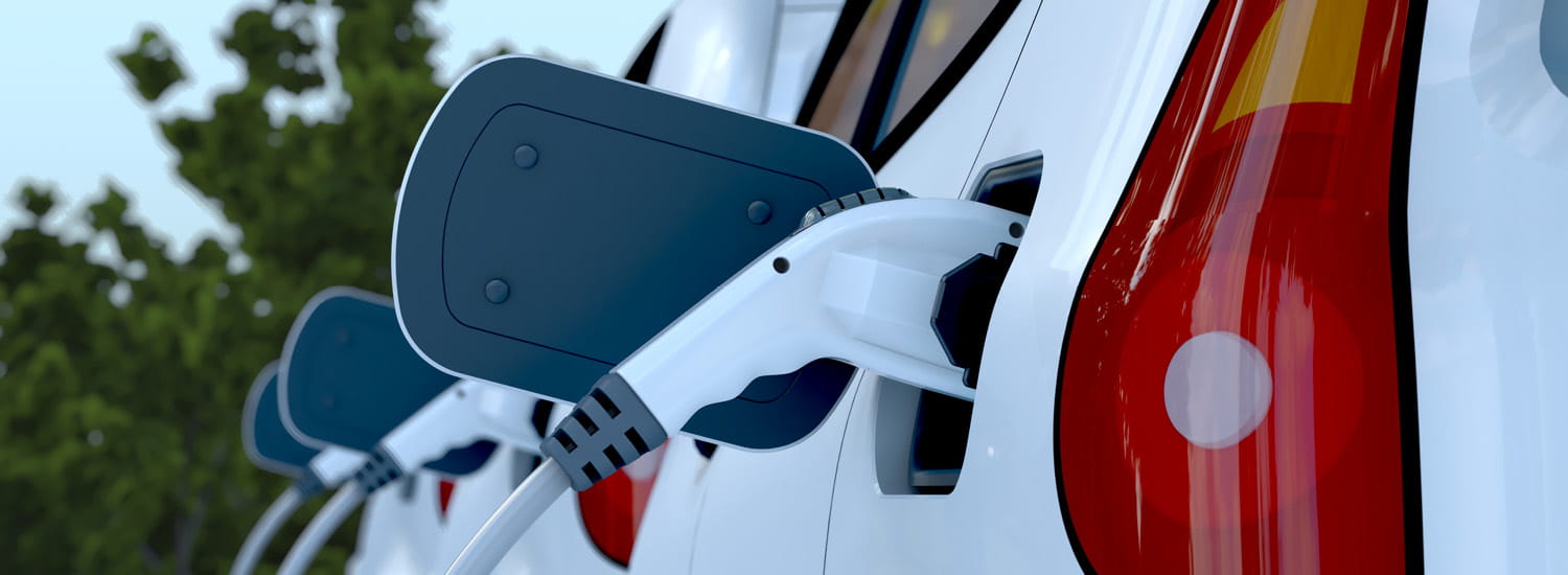 Close-up of fleet of electric vehicles being charged