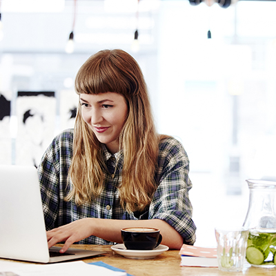 Woman sitting at desk typing on laptop