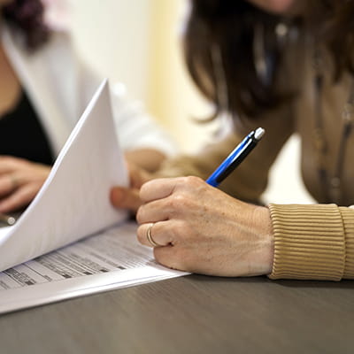 Close-up of woman signing document