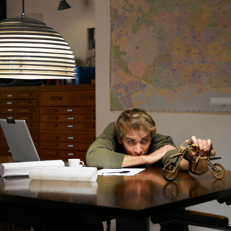 Young man sitting at desk playing with a desk toy