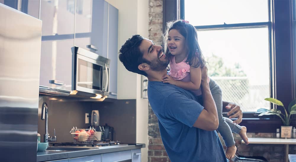 Landlord Insurance banner - father holding his daughter in the kitchen of their rental property