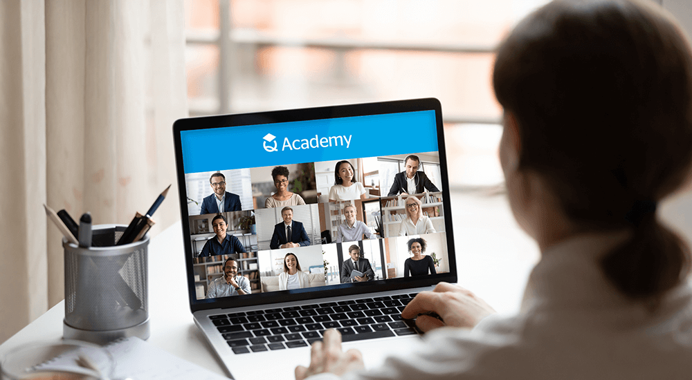 Back view of a man attending a QBE Q Academy virtual online training course on his laptop