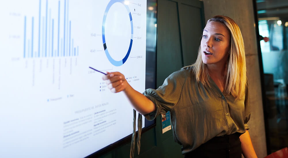 Data Story Telling - young woman talking to a presentation on a whiteboard