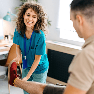 Female doctor/therapist helping injured man with rehabilitation