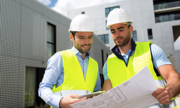 Engineer reviewing plans for construction site on digital tablet