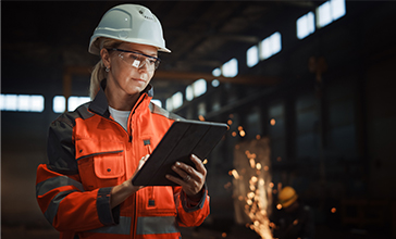 Female construction worker on site holding a tablet