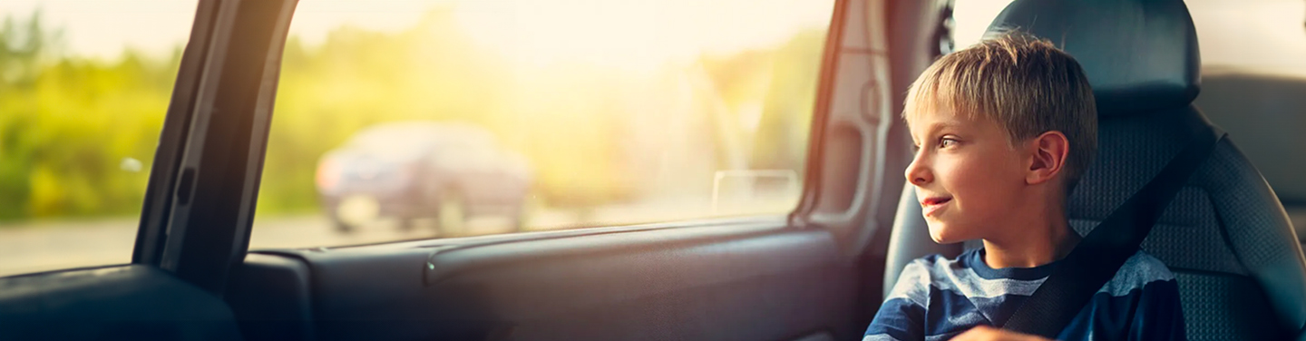 Comprehensive Car insurance - Young boy gazing out of a car window