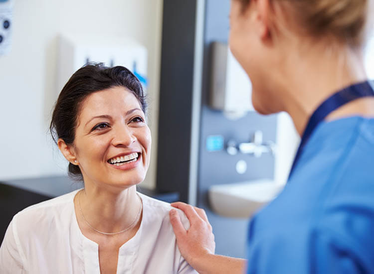 Female patient being reassured by doctor in hospital room