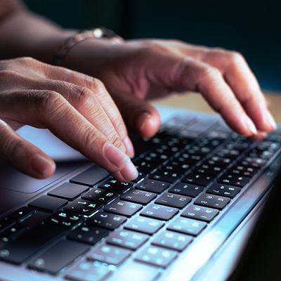 Close up of a hands on a laptop keyboard.
