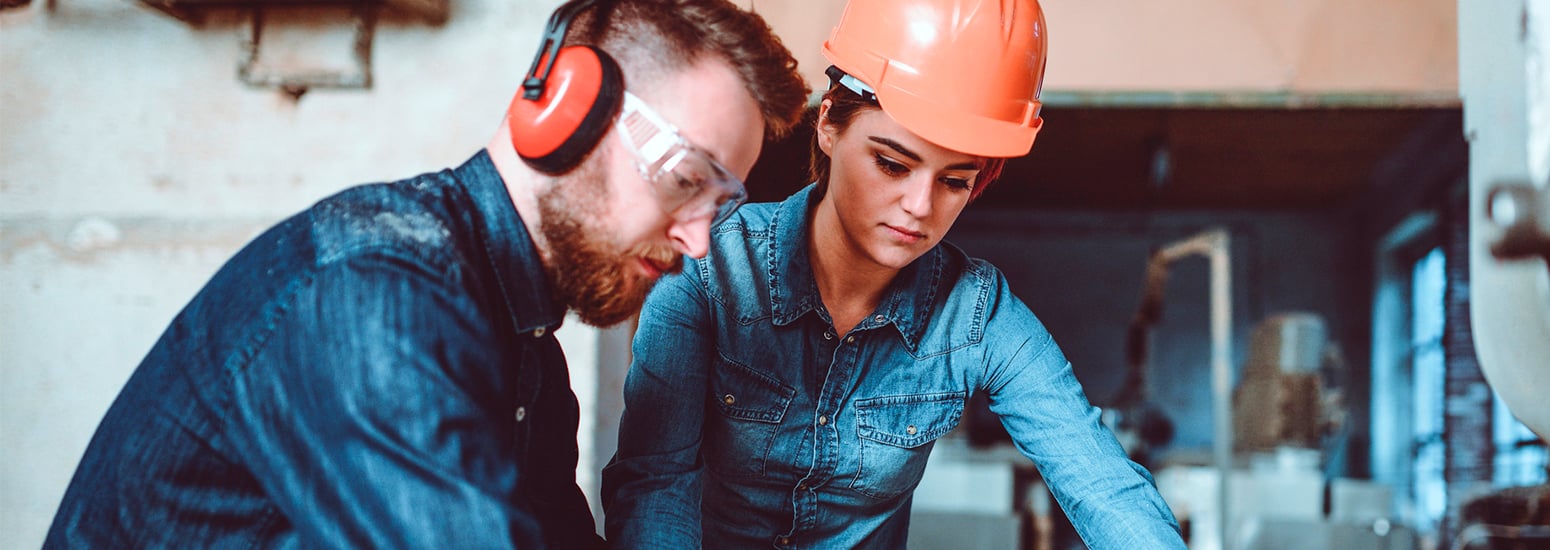 Man and woman wearing safety equipment in industrial setting
