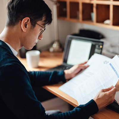 Man looking over documents while seated at his desk