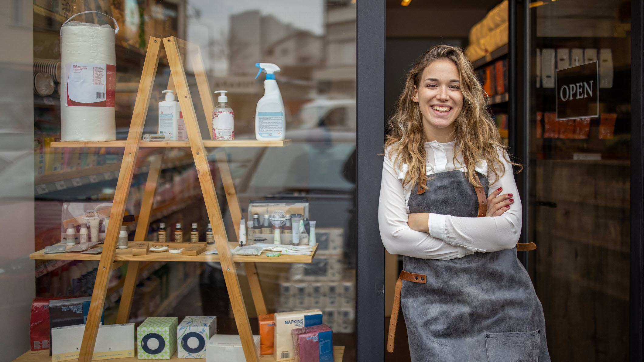 A young woman standing in her store doorway