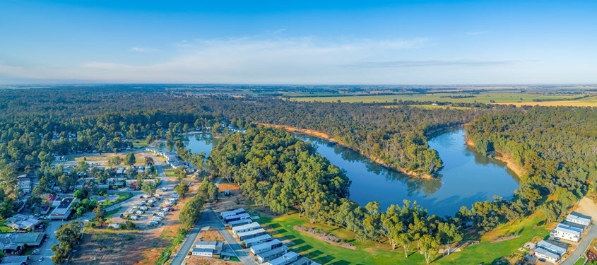 Aerial view of a regional Australian community beside a winding river, highlighting flood-prone landscapes and resilience