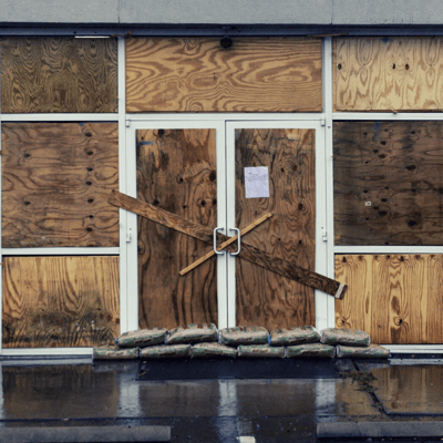 Boarded up and sandbagged shop front in preparation for a cyclone