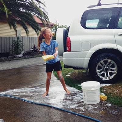 Father and Daughter having fun whilst washing the car