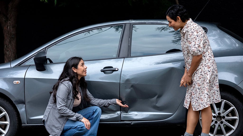 Women analyzing severe car accident damage after a vehicle collision