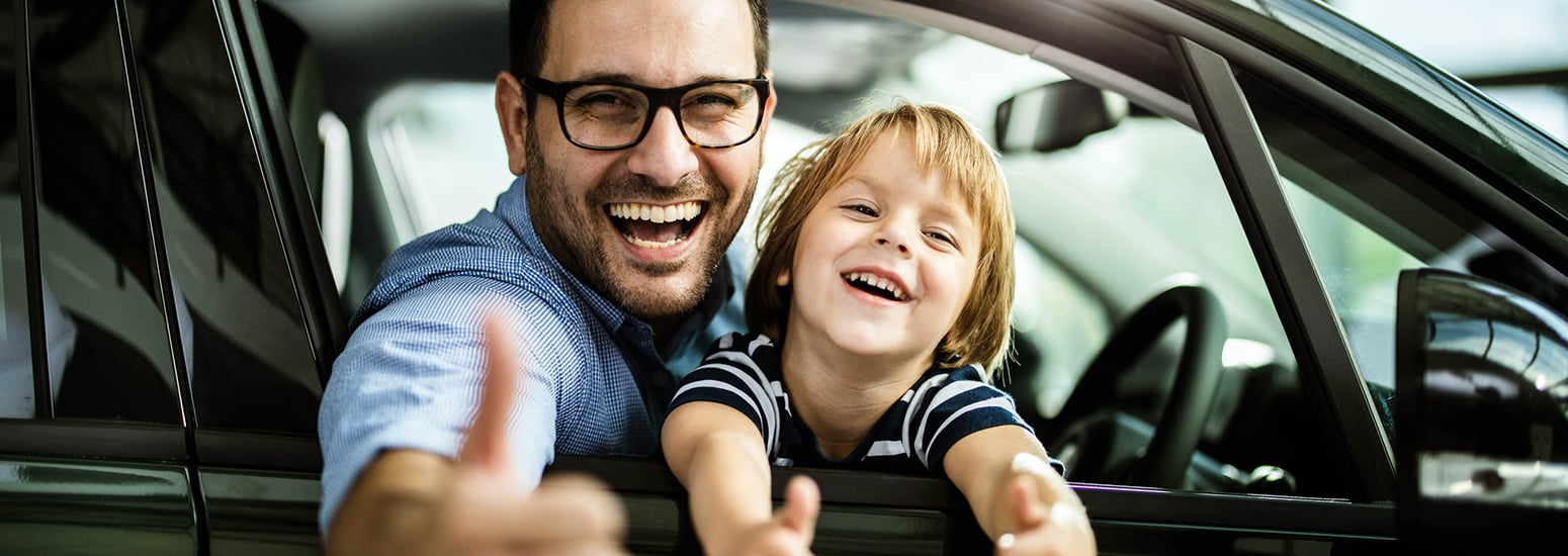 Father and son giving the thumbs up through a car window