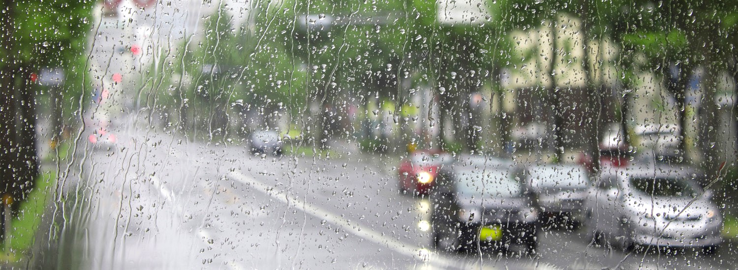 Looking out a car windscreen streaked with rain