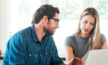 Young couple sit and talk about a home building insurance claim