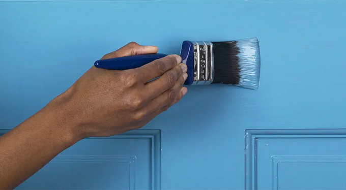 Home maintenance - painting door with paintbrush