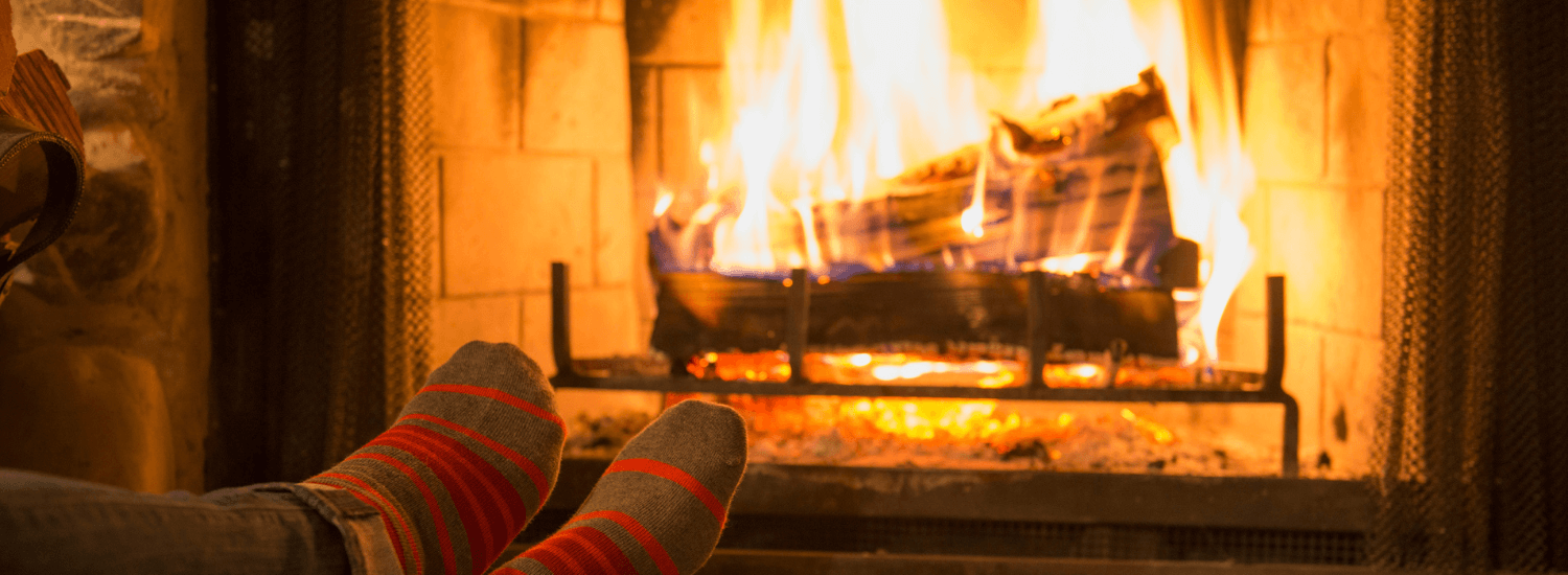 Feet in wool socks warming by cozy fire