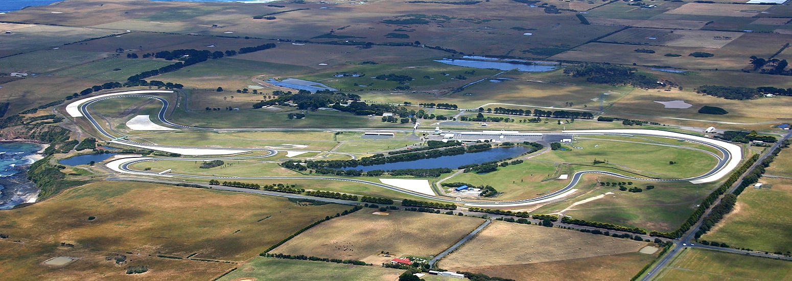 Aerial view of Phillip Island Grand Prix Circuit in Victoria, Australia, featuring winding motorbike racing track surrounded by lush greenery - showcasing comprehensive motorcycle insurance, motorbike insurance quotes, and QBE’s trusted insurance for motorcycles across Australia.