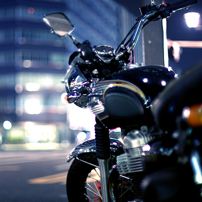 Close up of a motorbike parked on a street at night to accompany an article promoting QBE bike insurance