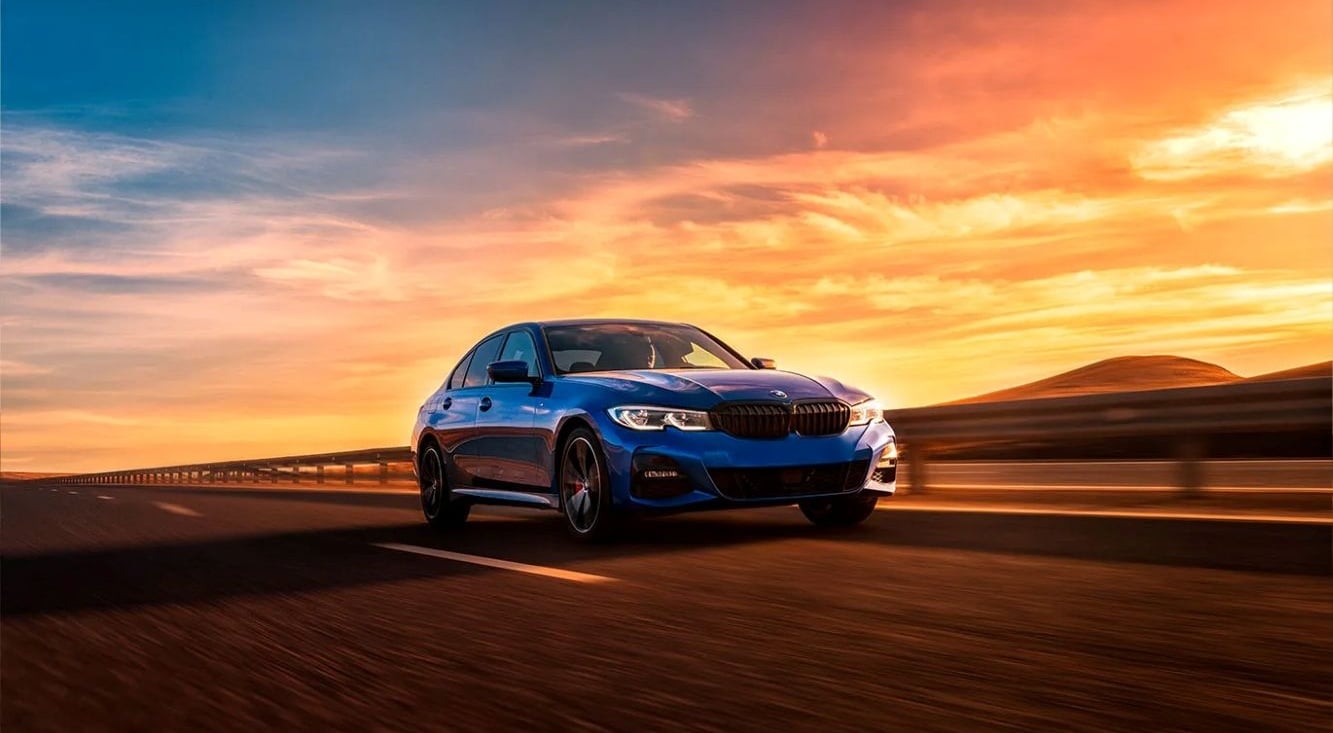 Car driving on an open road at sunset