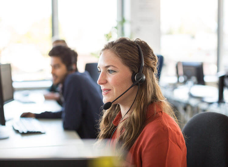 Female call centre representative wearing headphones working in office