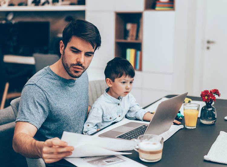 Father and young son working with documents and laptop