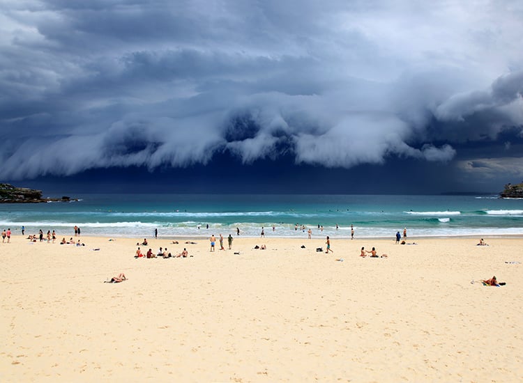 photo of storm clouds rolling in over a beach from the ocean