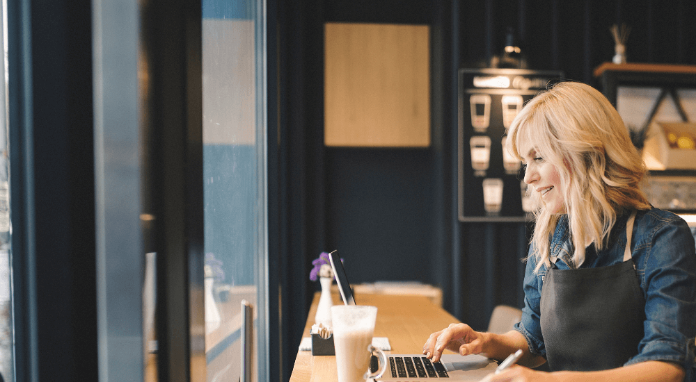 Coffee shop owner working on laptop