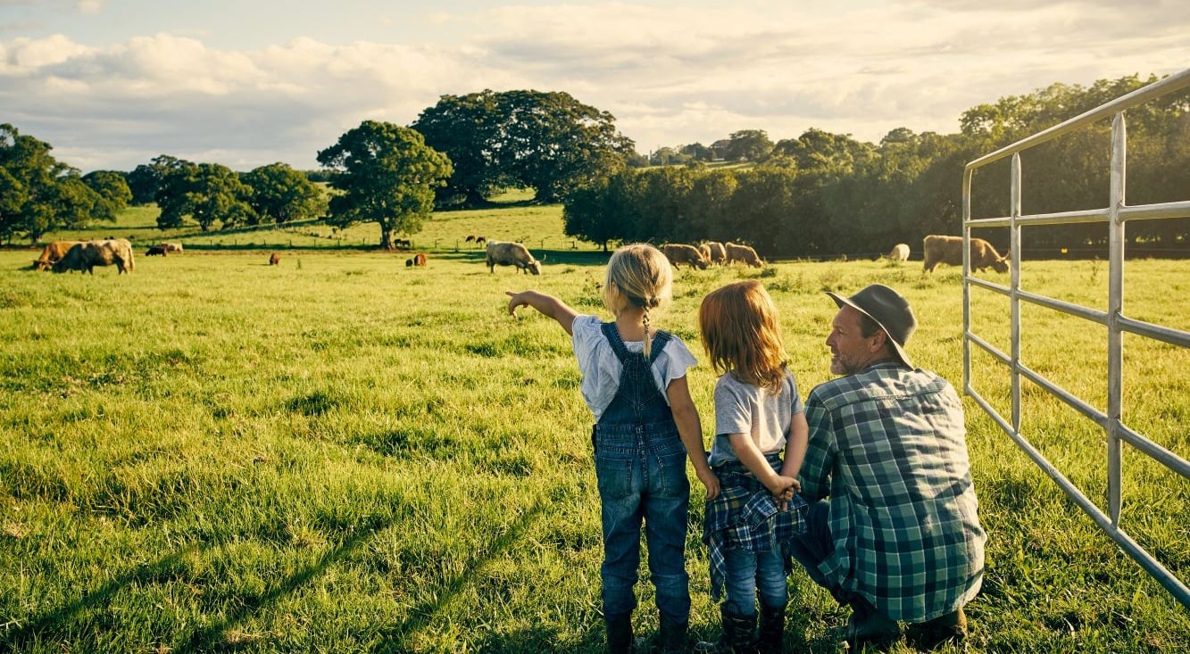 A farmer and his two children on a dairy farm
