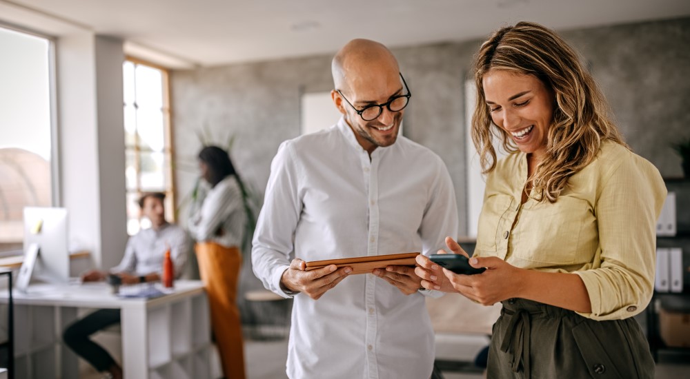 Male and female collaborating with their digital devices