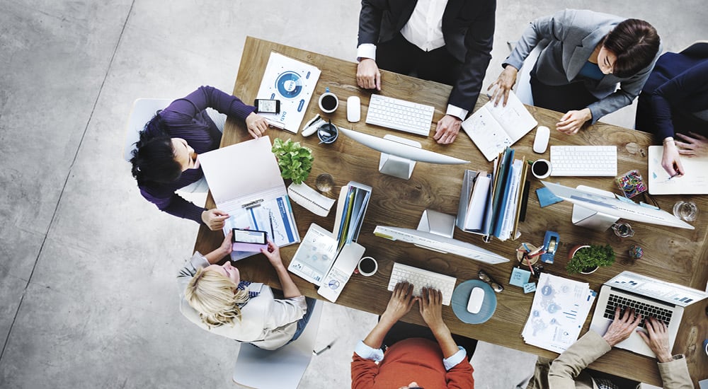 Overhead of colleagues having a meeting in modern office.