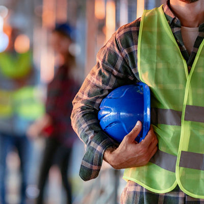 Close up of tradesman holding hard hat under arm