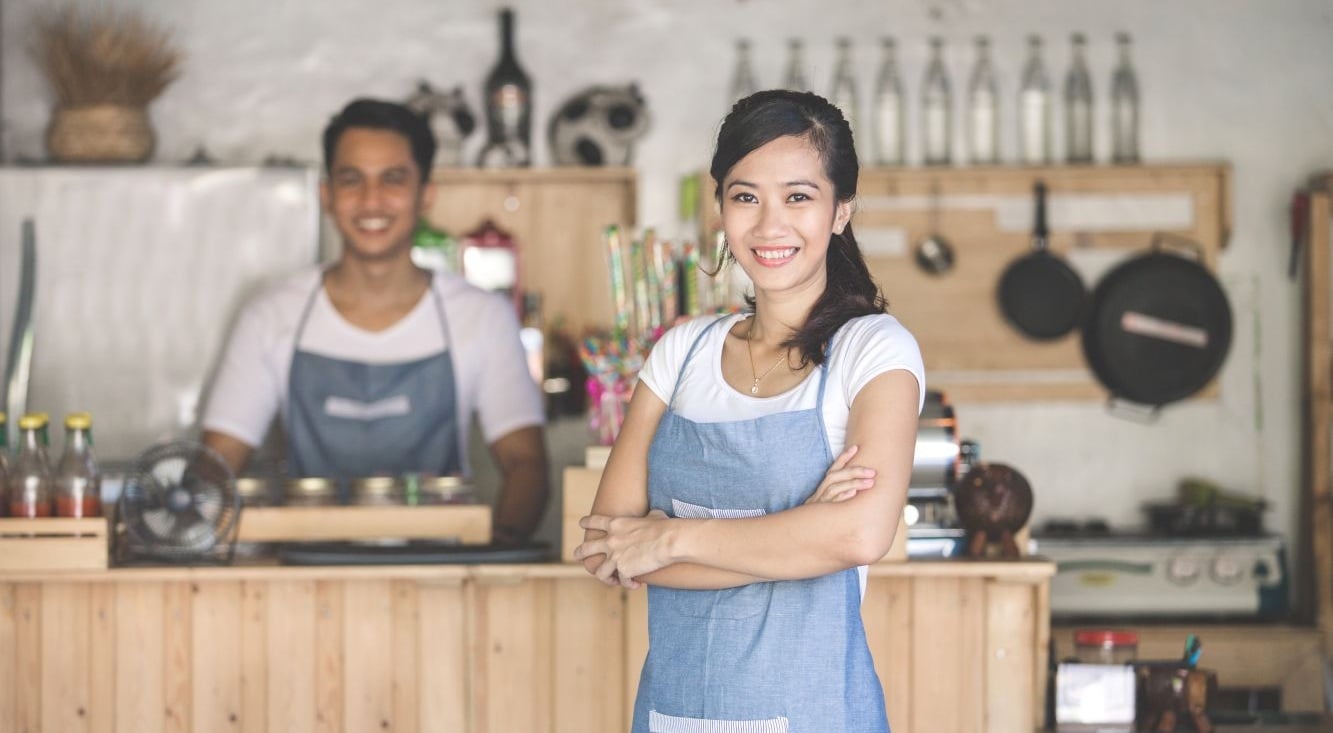 Small business owners working behind a retail counter, highlighting business operations and commercial insurance needs