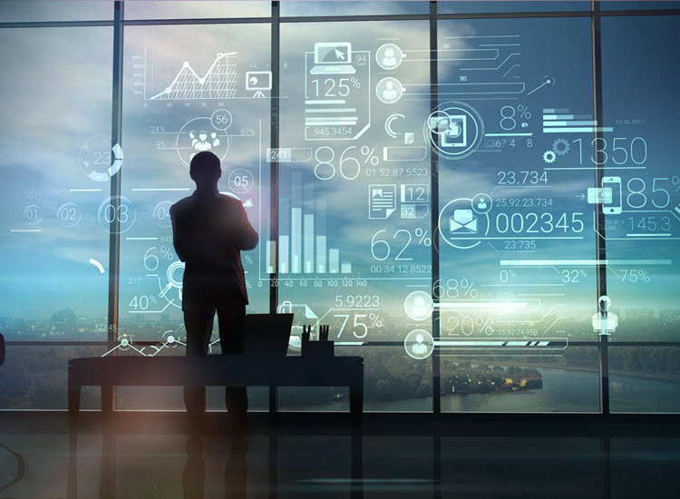 Businessman looking at financial analytics virtual screen in front of large glass windows overlooking a city skyline at night.