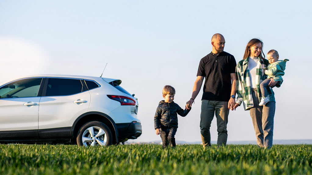 Young family with kids travelling by car, stopped in the field
