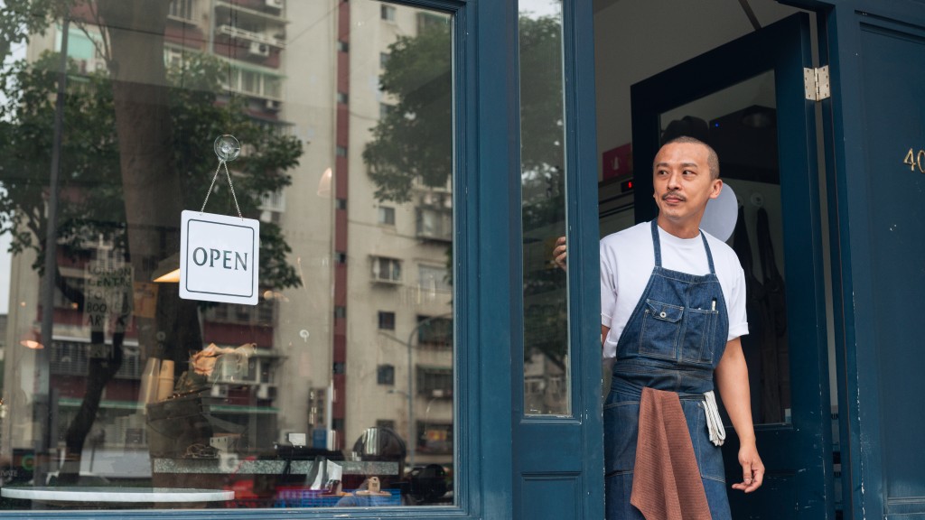 Coffee shop business owner with open sign